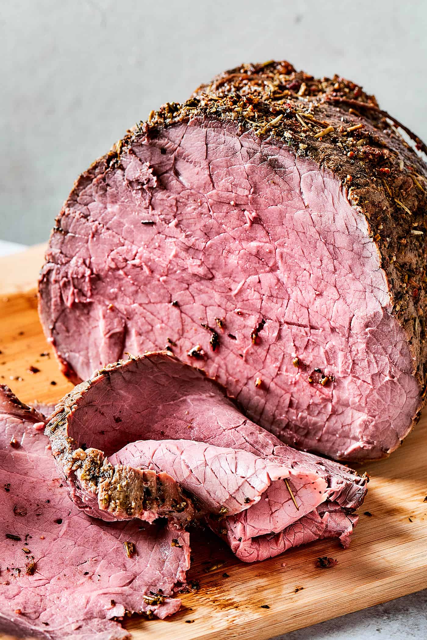 roast beef on a wood cutting boards, with some of it sliced