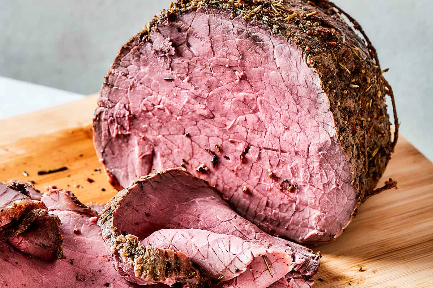 roast beef on a wood cutting boards, with some of it sliced