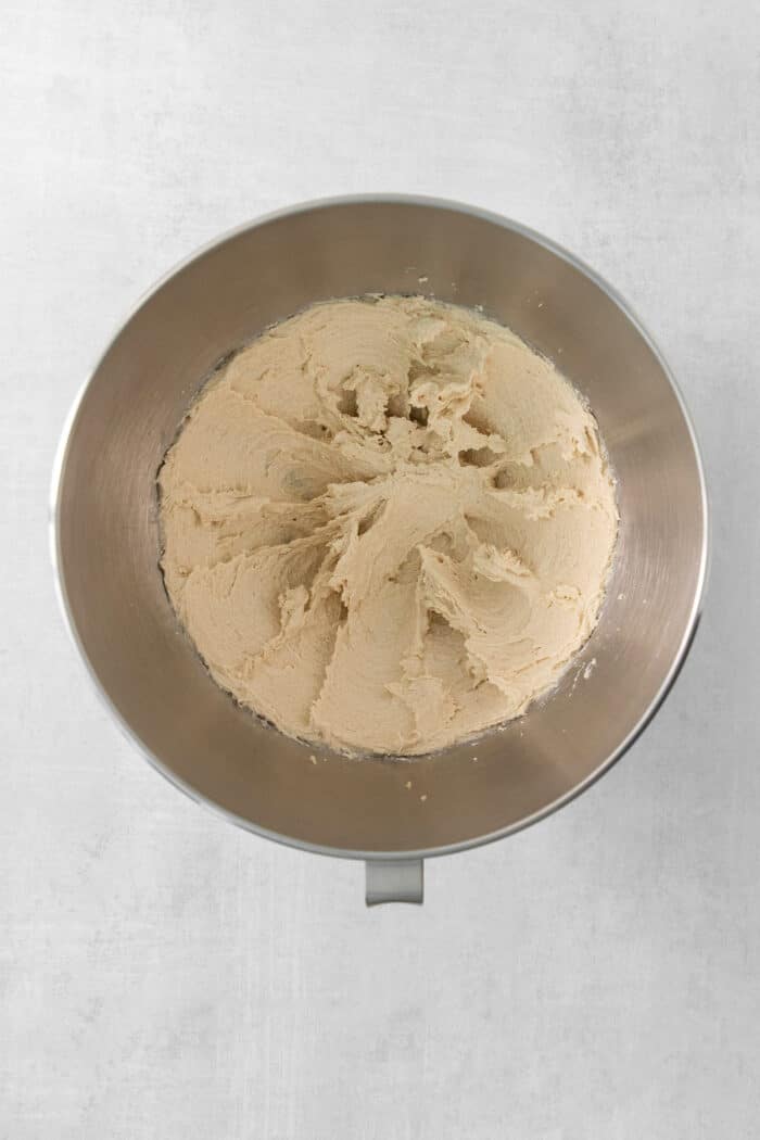 A metal bowl of blended butter and sugar.