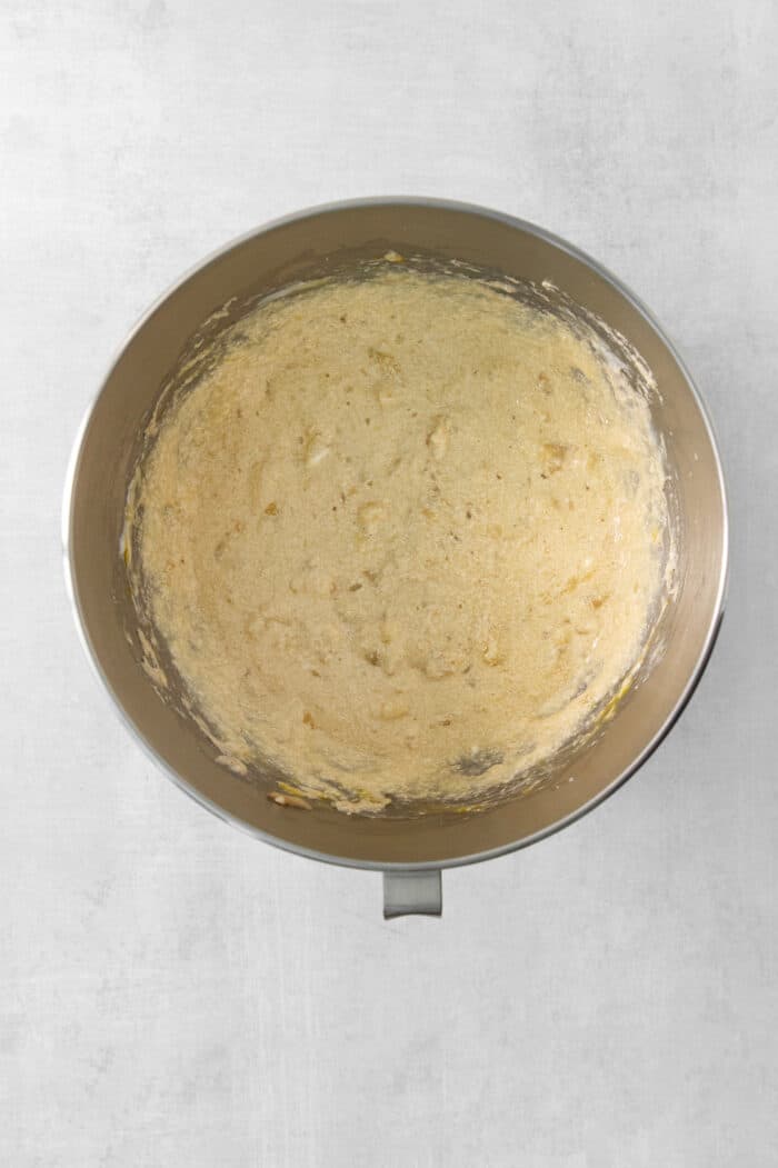 The batter for banana coffee cake is mixed in a metal bowl.