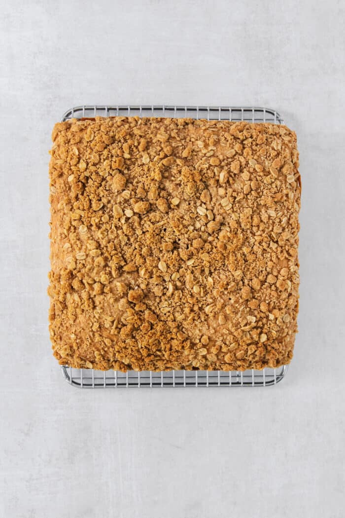A golden, toasted streusel tops a baked pan of banana coffee cake.