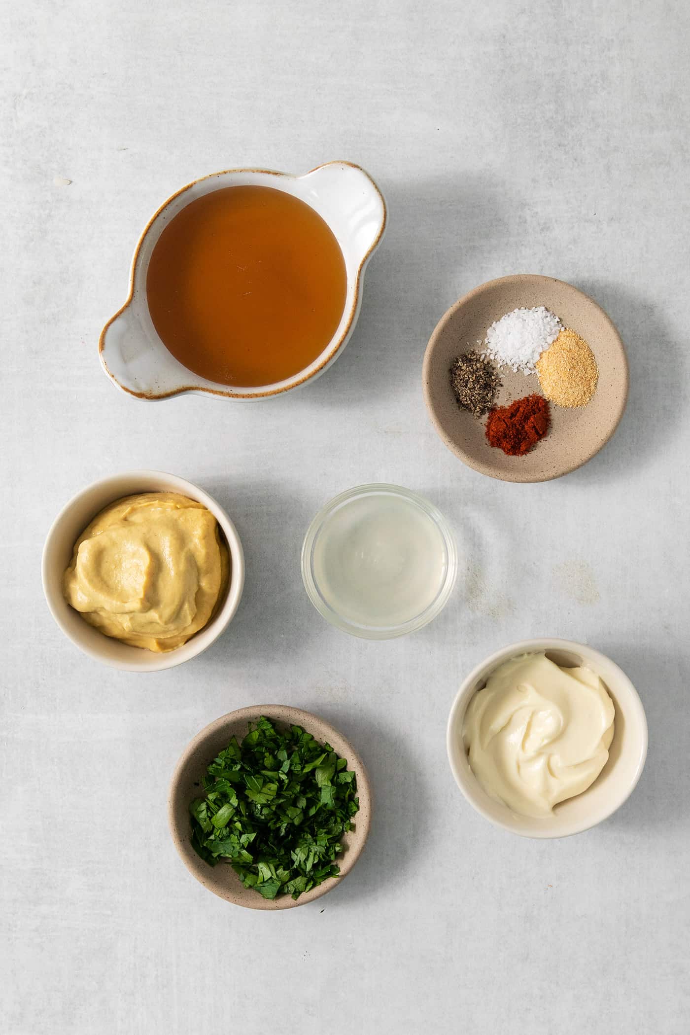 Ingredients for honey mustard dip are shown portioned out: honey, Dijon mustard, mayonnaise, spices, parsley, salt.