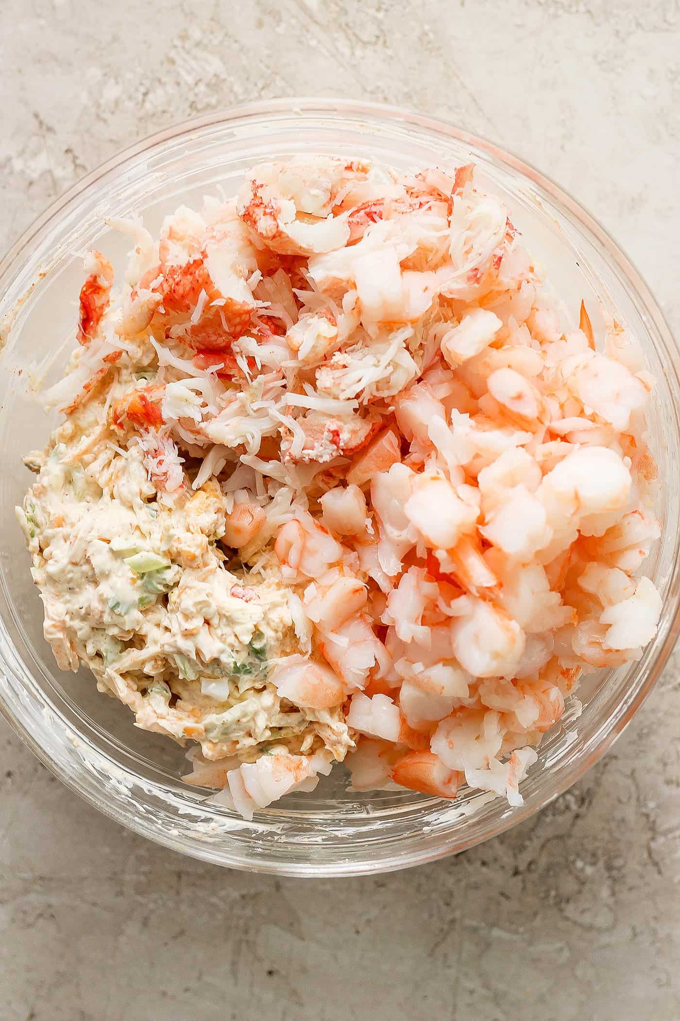 A bowl of raw shrimp and crab and cheese.