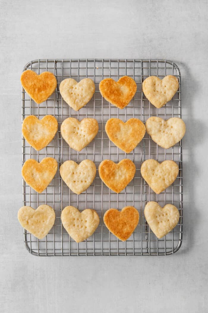 Baked heart shaped cream wafter cookies cool on a wire rack.