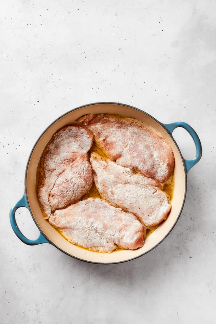 Chicken cooks in olive oil in a dutch oven.