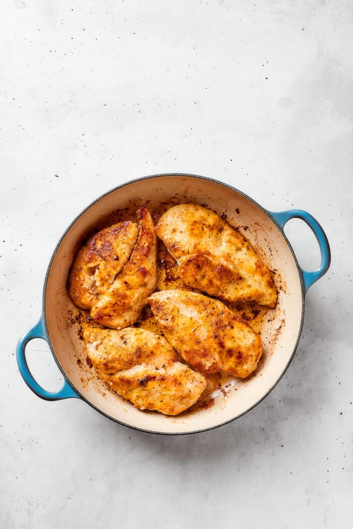The chicken starts to brown in the dutch oven.