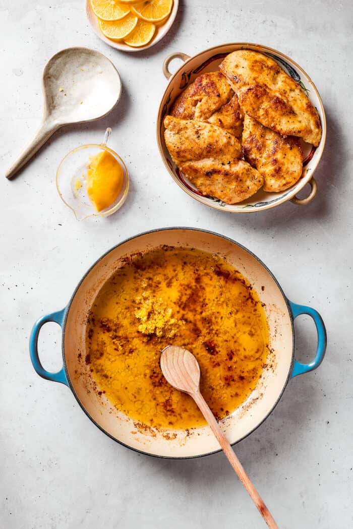The cooked chicken is removed and placed aside while lemon zest and broth is added to the pot.
