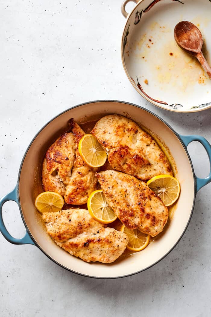 The cooked chicken breast is added back to the sauce in the pot.