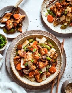 Moo goo gai pan is shown on a plate surrounded by more plates of moo goo gai pan.