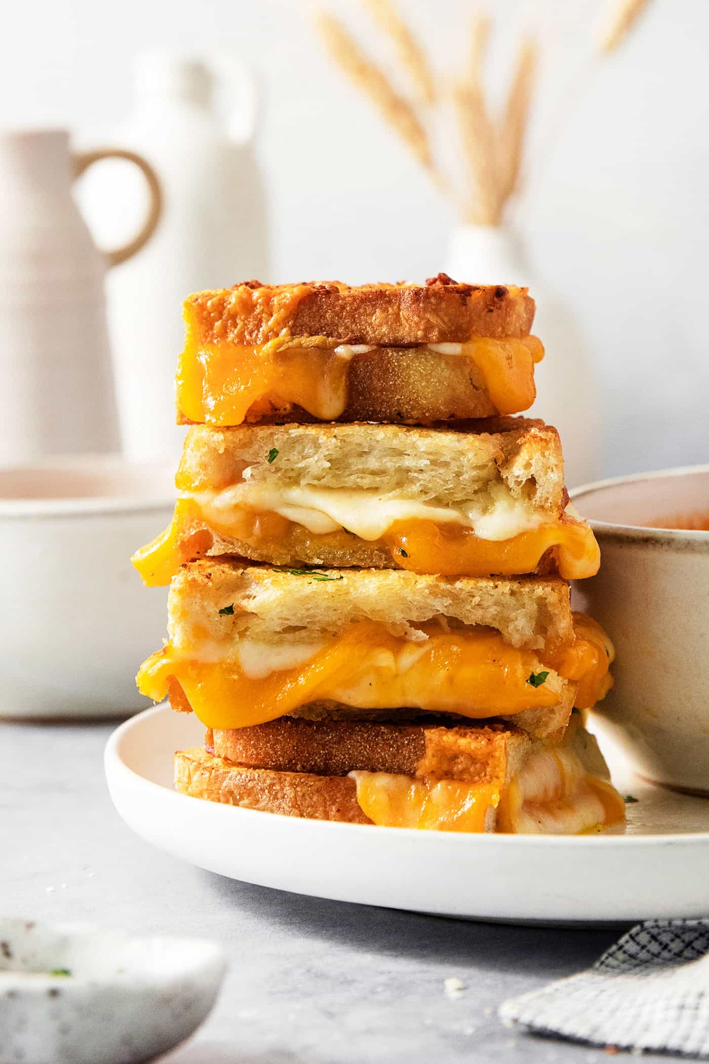 A stack of slices of air fryer grilled cheese sandwiches shows the melted cheese inside.