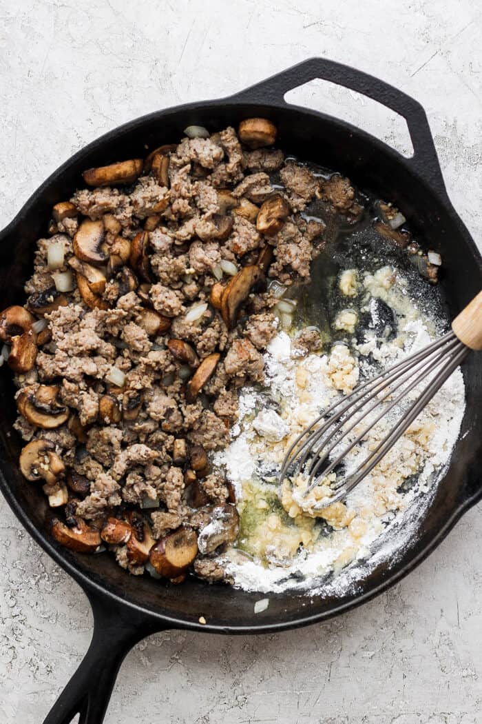 Flour is whisked into a skillet of mushrooms, sausage, and aromatics to make a gravy.