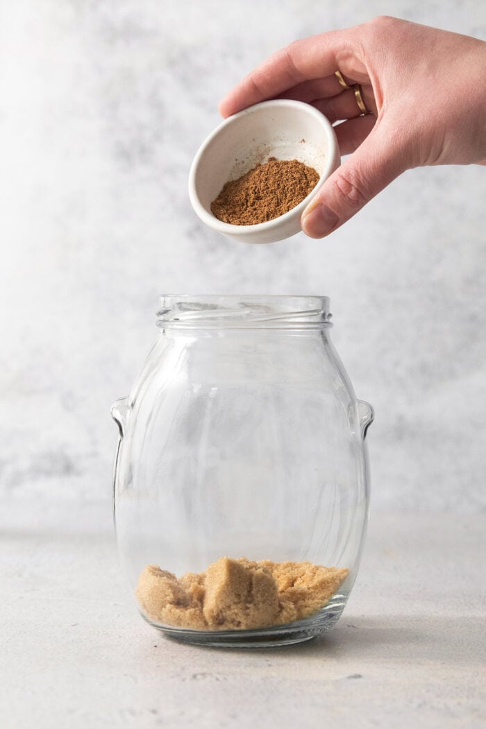 adding chai spice mix to a large jar