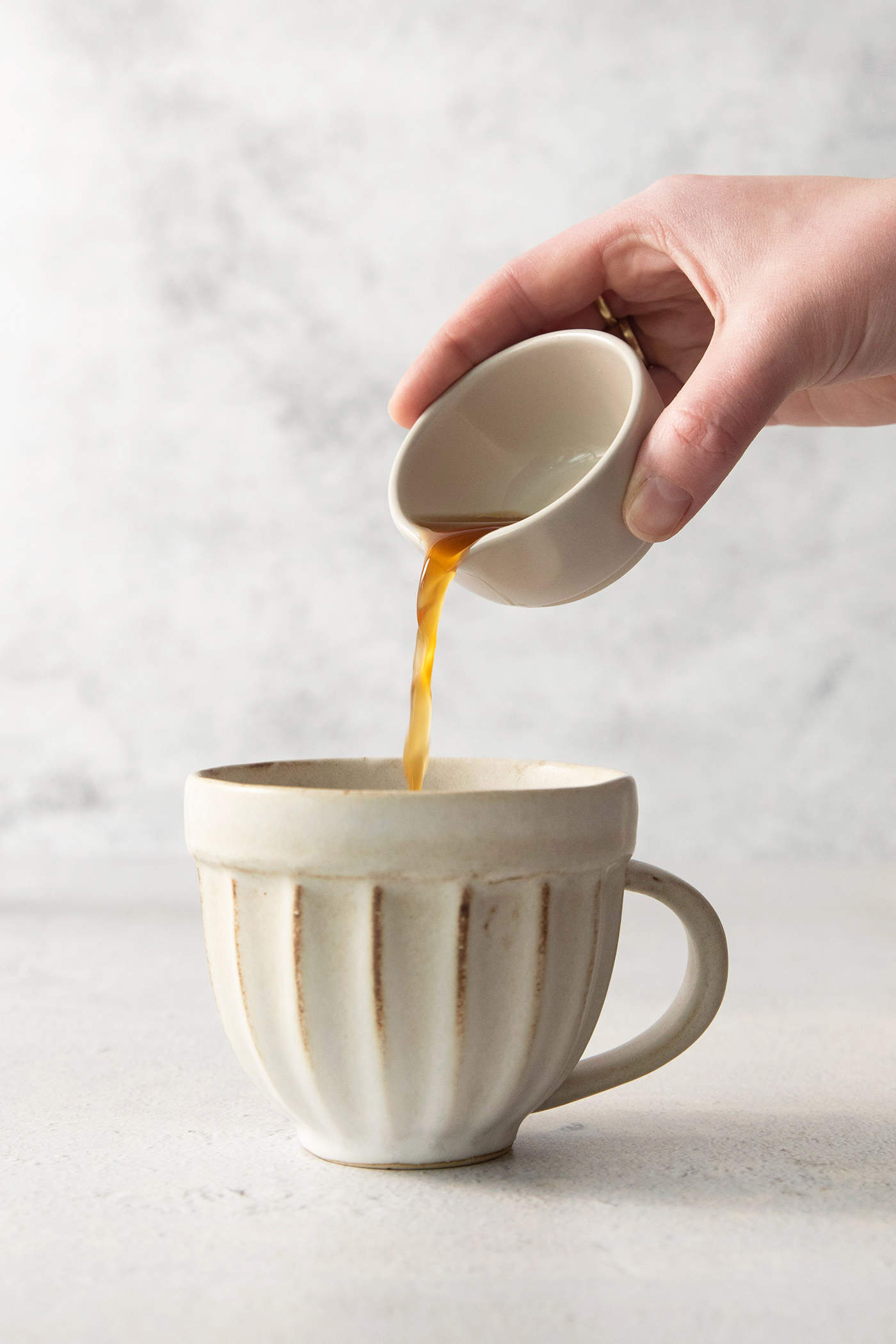 adding chai concentrate to a mug