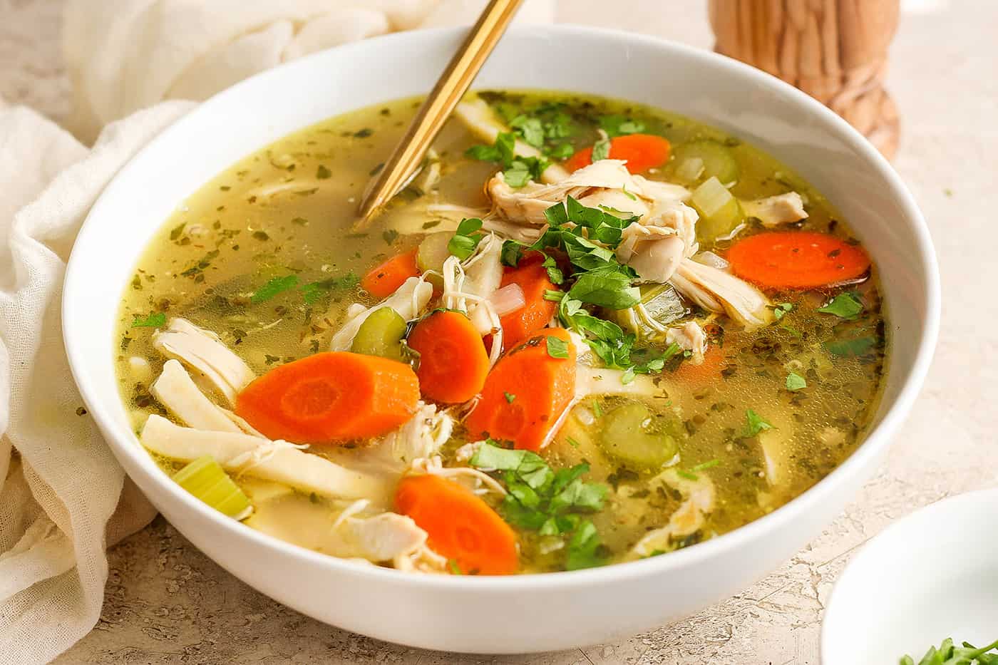 Chunks of chicken and vegetables are seen in a bowl of chicken noodle soup.
