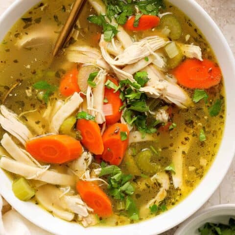 Chunks of chicken and vegetables are seen in a bowl of chicken noodle soup.