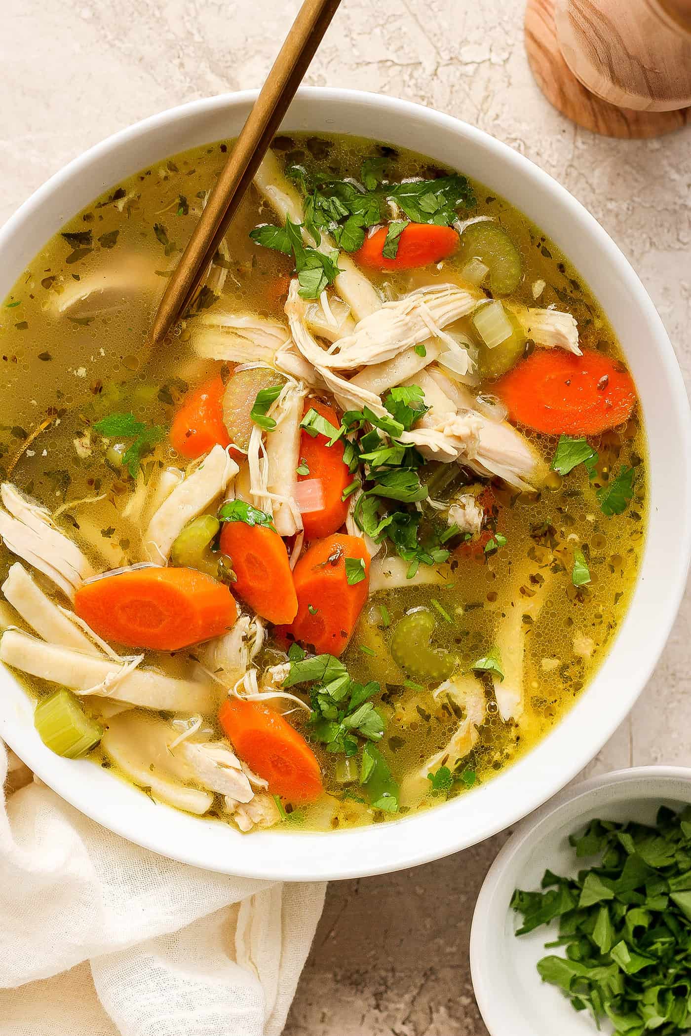 Chunks of chicken and vegetables are seen in a bowl of chicken noodle soup.