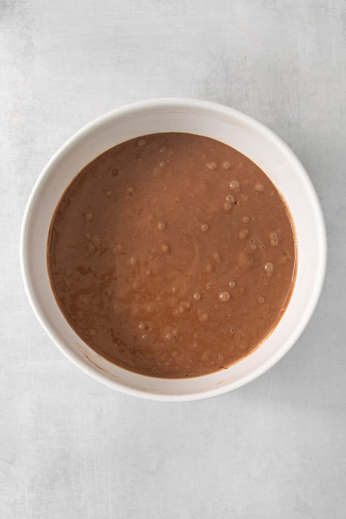 Chocolate cake batter in a white bowl.