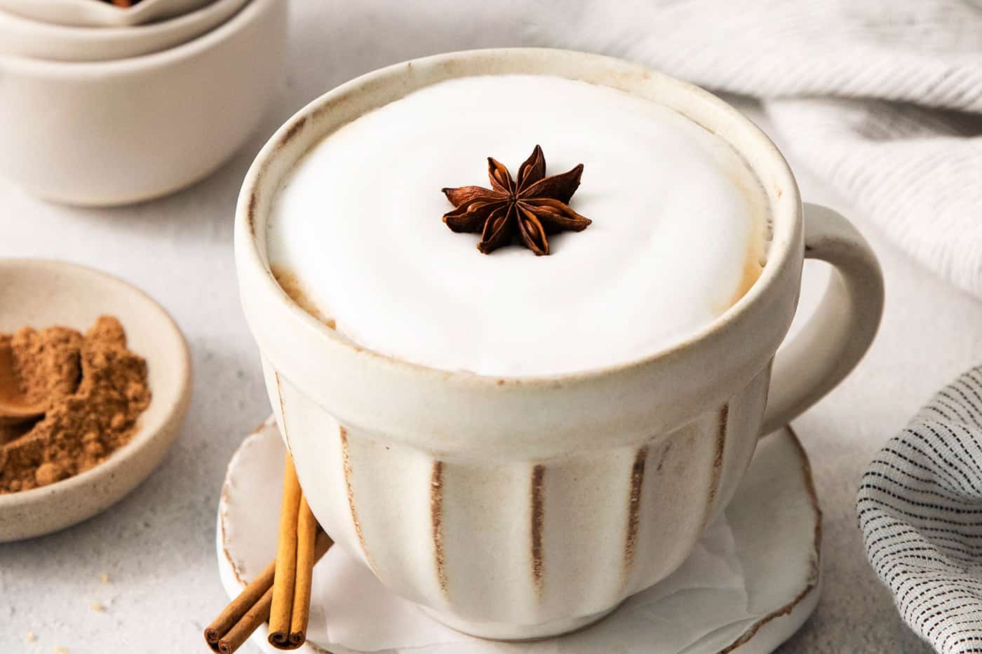 dirty chai latte in a mug, with star anise floating on the frothed milk