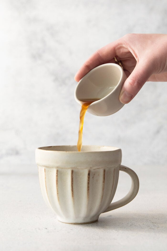 pouring chai concentrate into a mug