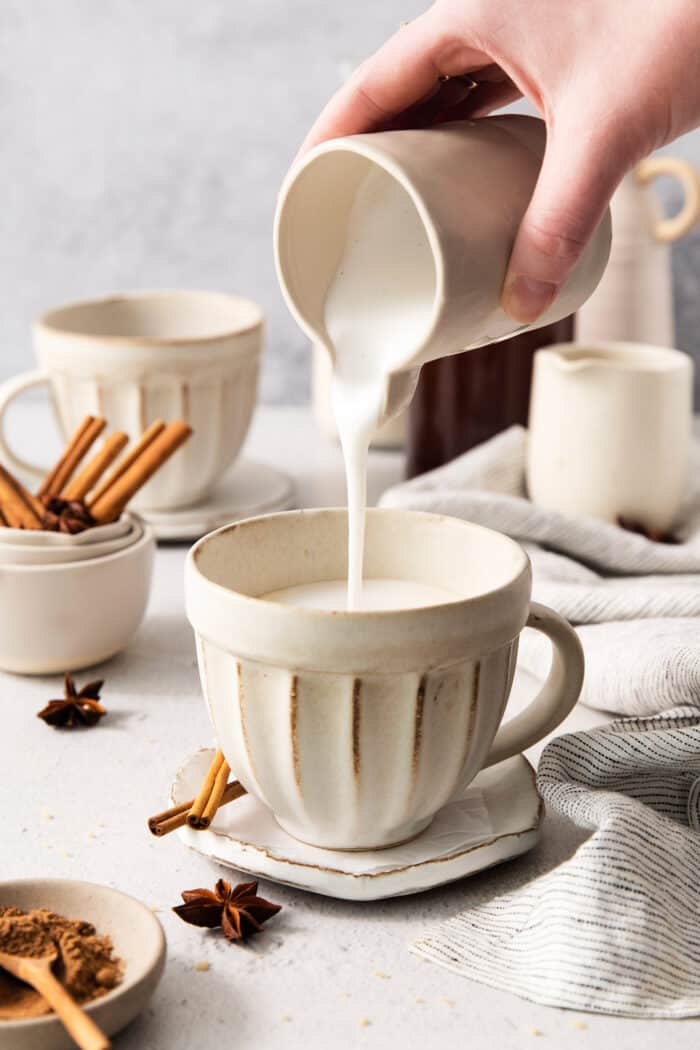 pouring frothed milk into a mug