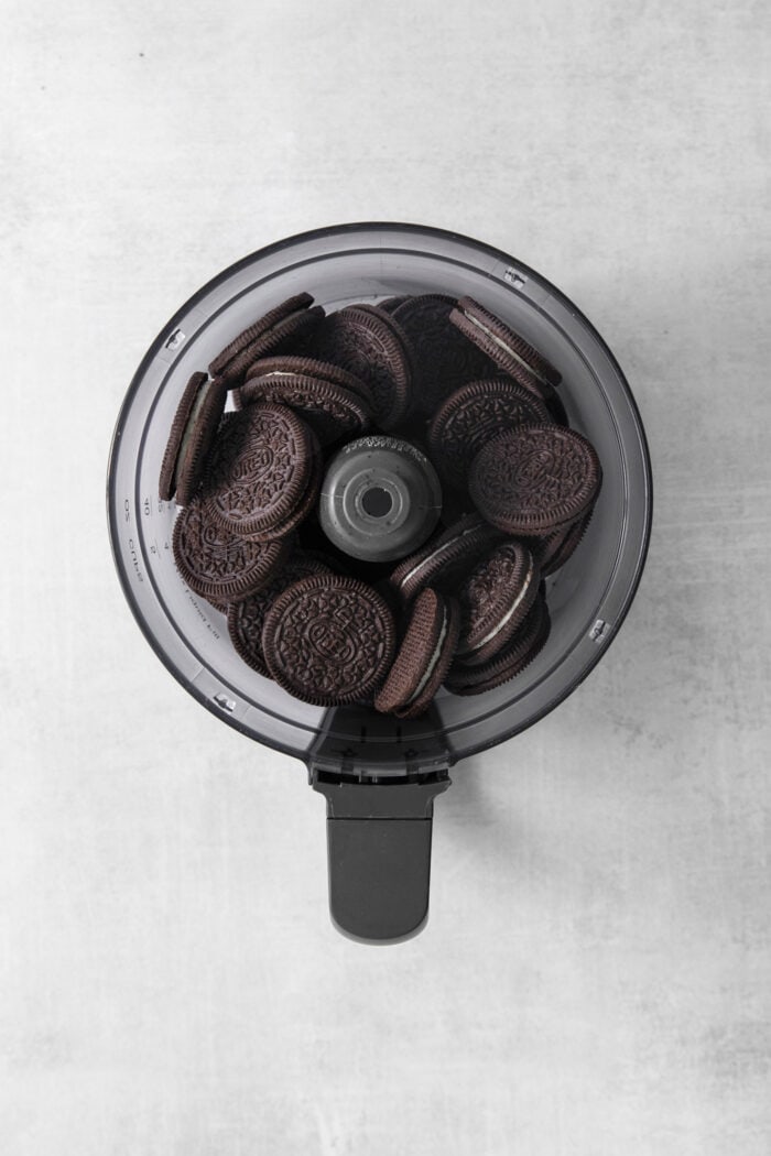 Whole Oreos are added to a food processor.