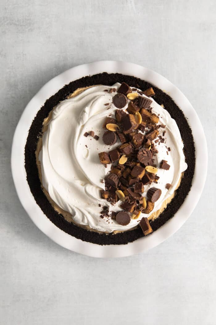 The pie is topped with chopped peanut butter cups.