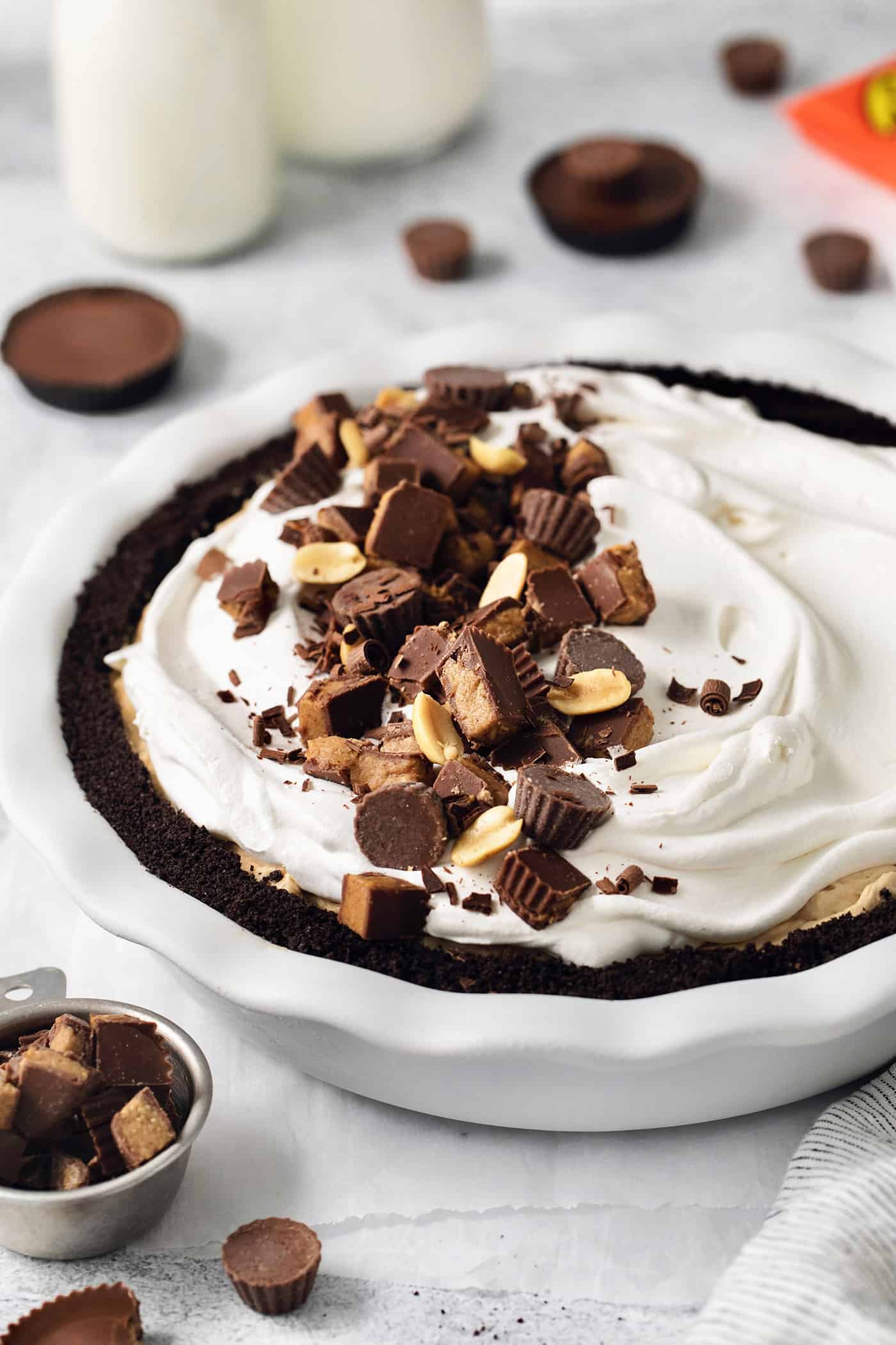 A Reeses pie topped with whipped topping and chopped peanut butter cups.