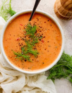 overhead photo of a bowl of tomato bisque in a white bowl