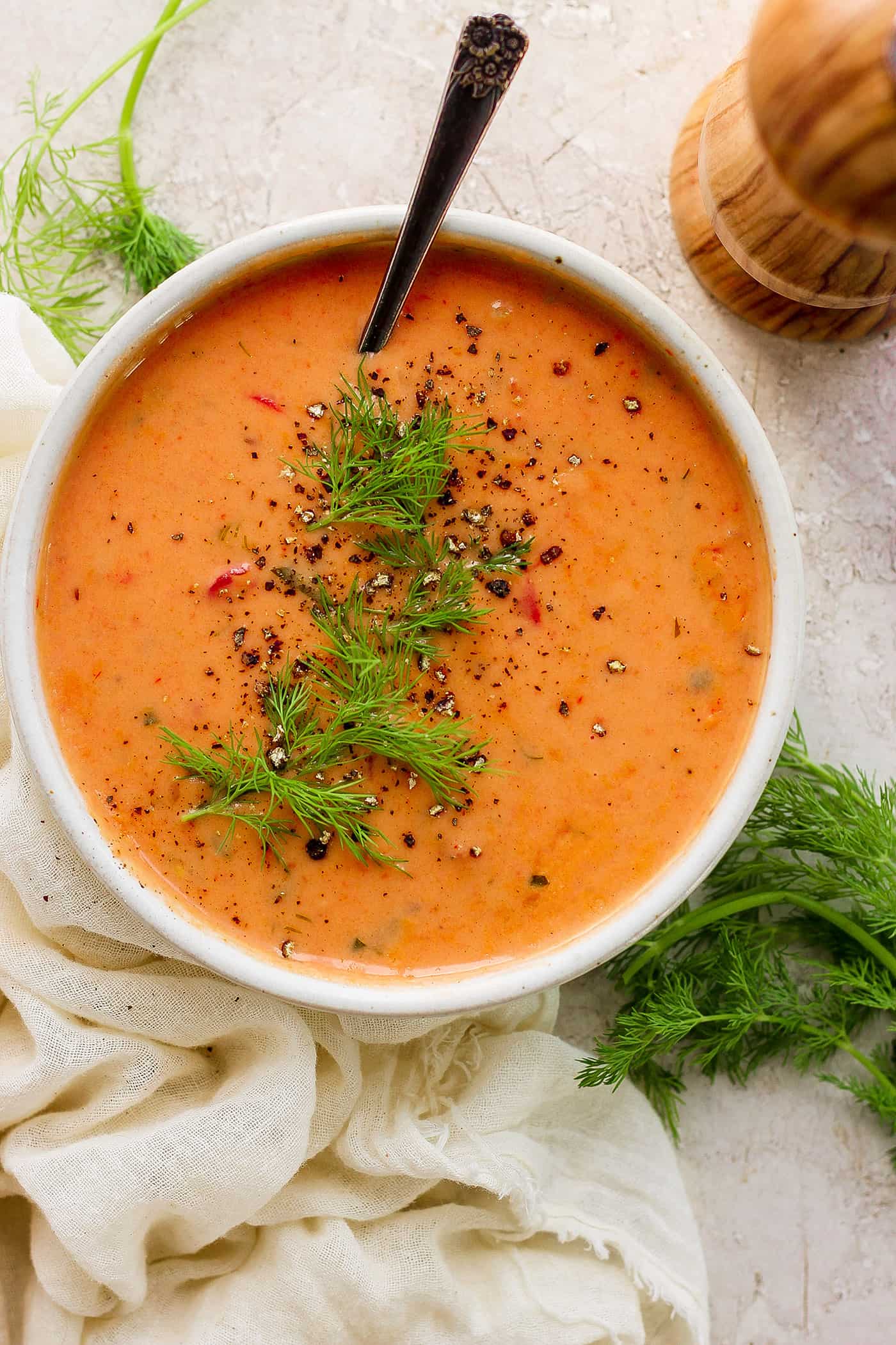 overhead photo of a bowl of tomato bisque in a white bowl