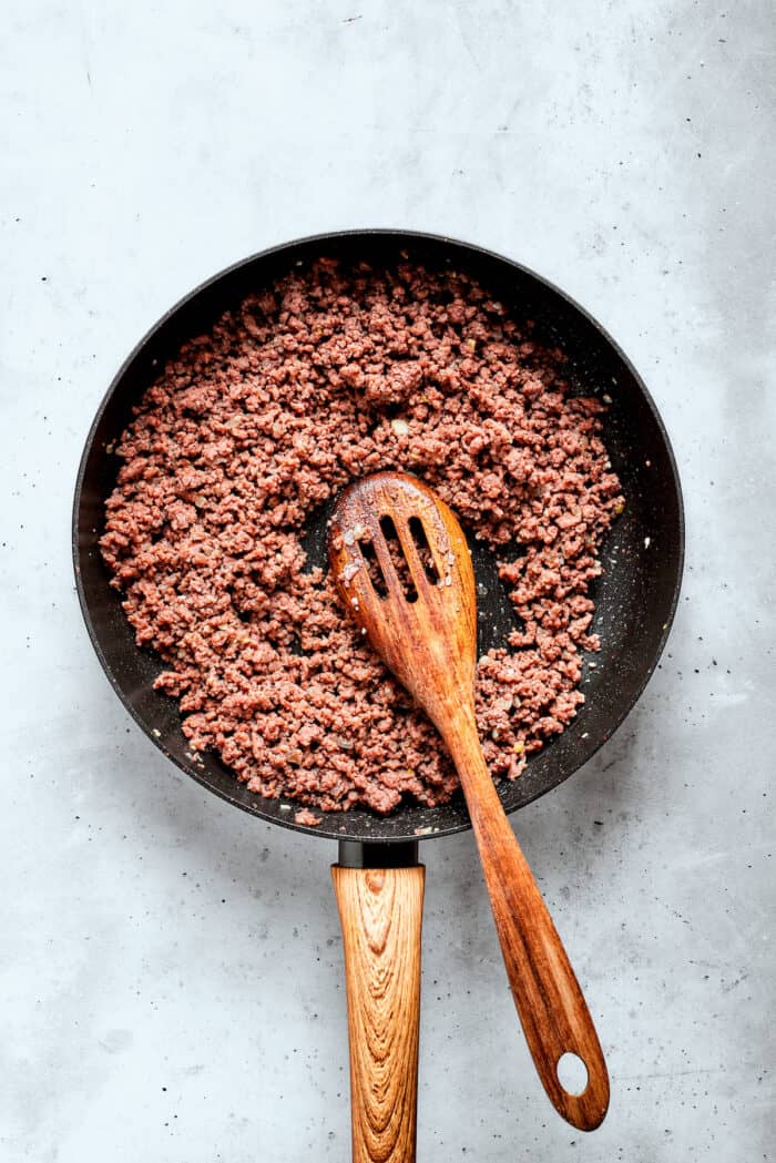 Ground beef is browned in a skillet.