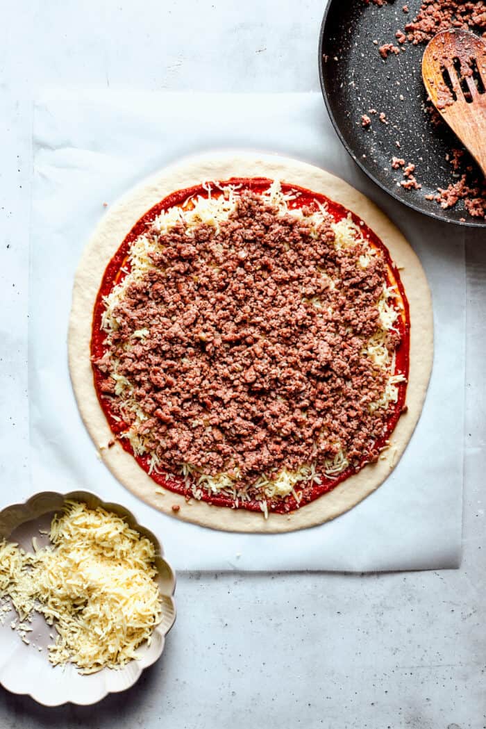 The cooked meat is added to the pizza.