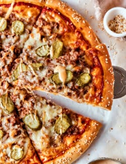 Slices of cheeseburger pizza on a white background.