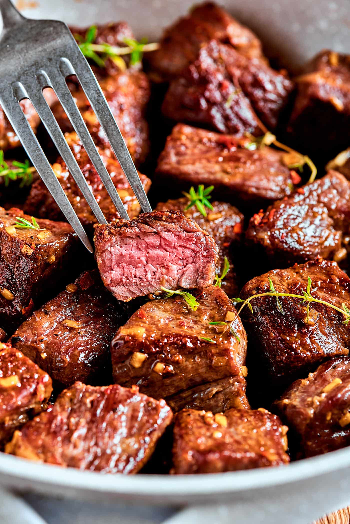 cubes of ribeye steak cooked in garlic butter, in a skillet