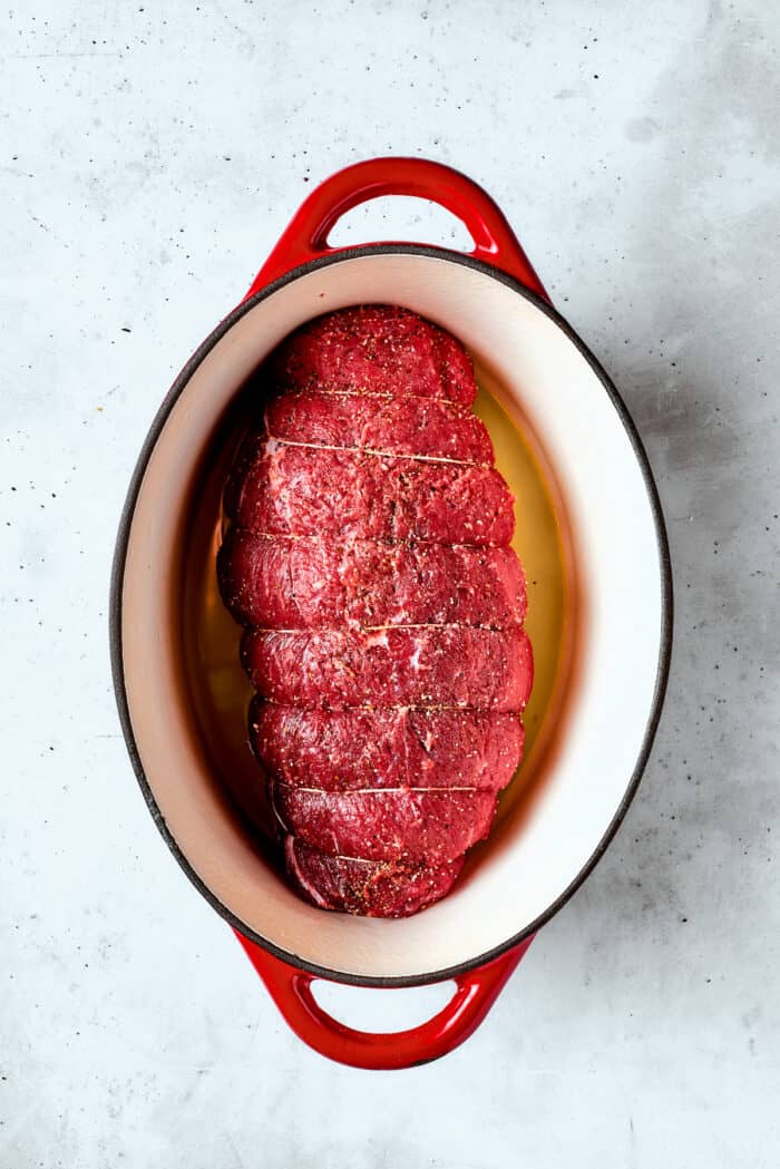 The uncooked roast is added to the pot.