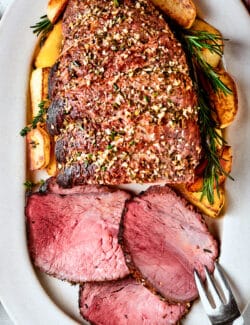 The seasonings for a sirloin tip roast are shown on top of the roast.