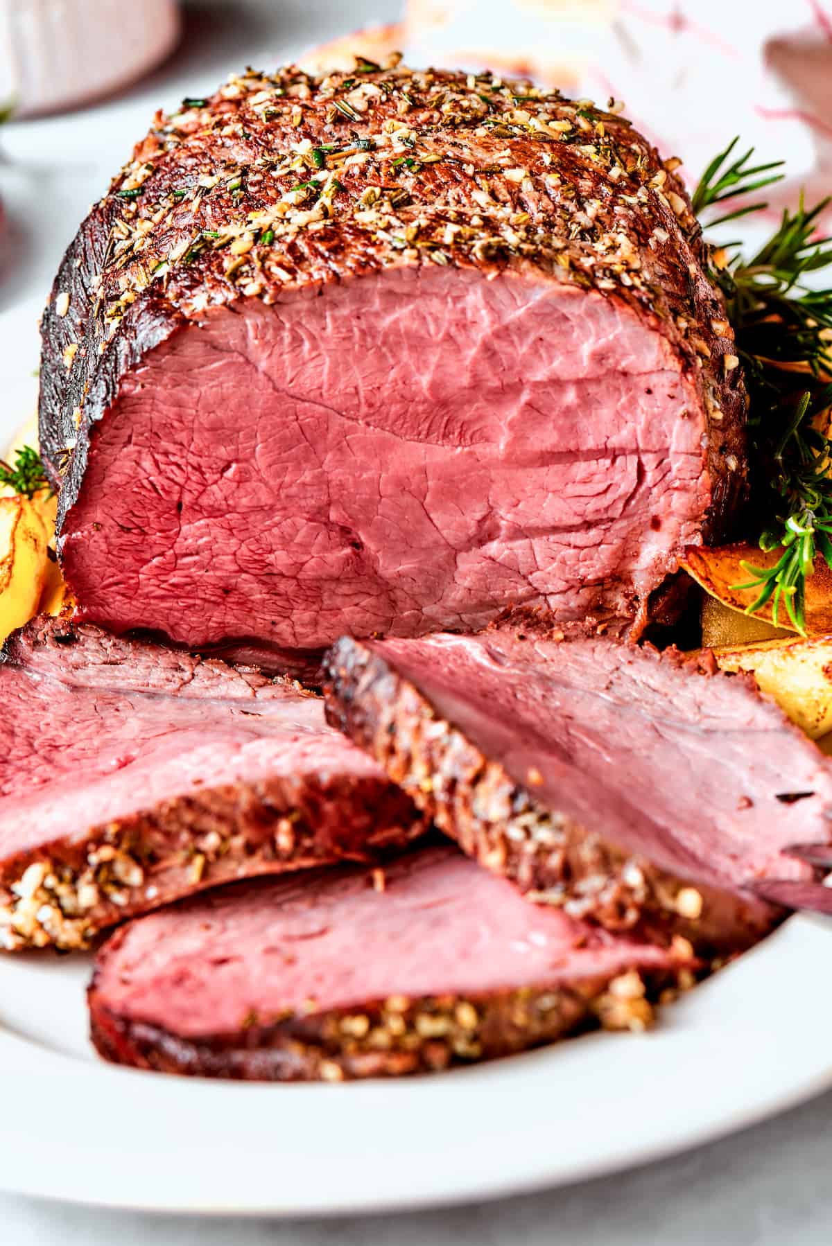 A sirloin tip roast on a platter with slices of roast.