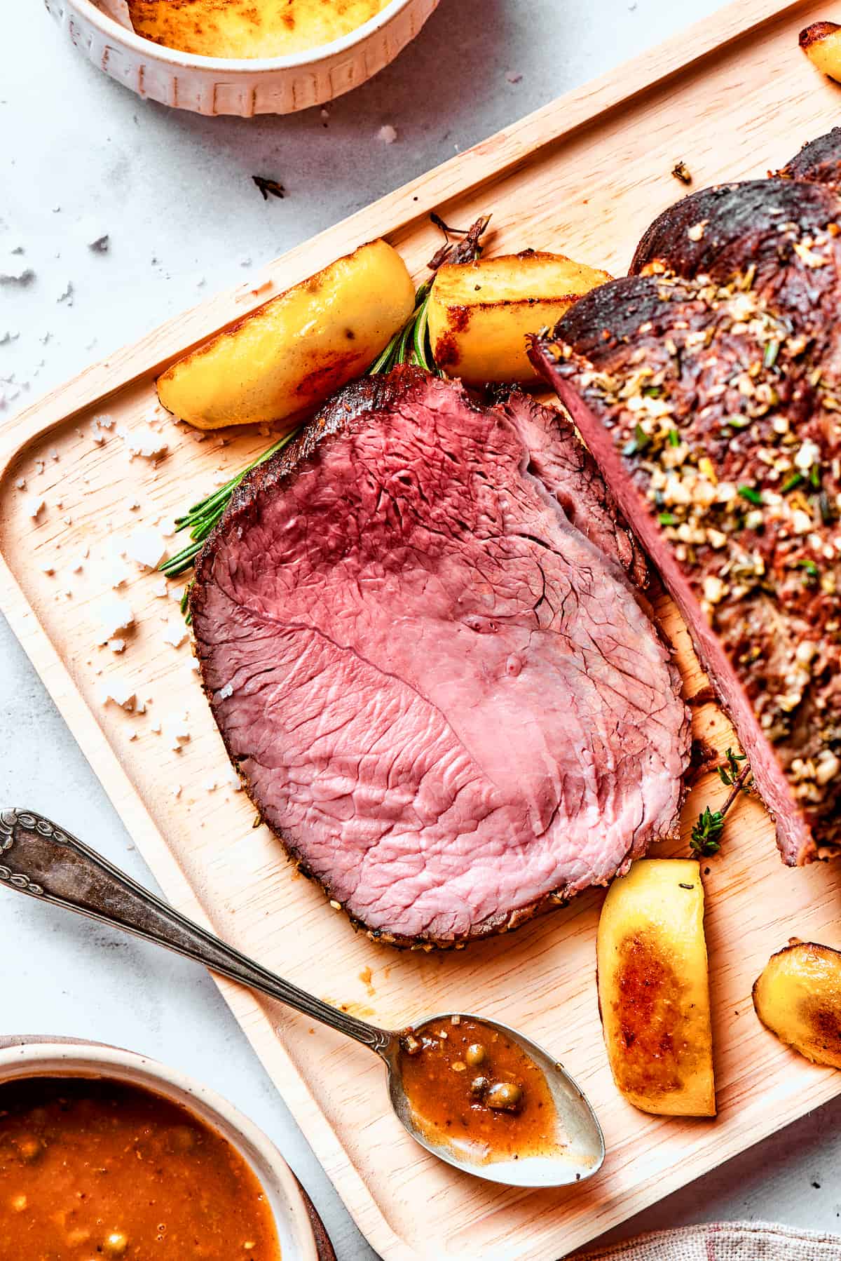 A pink slice of sirloin tip roast is cut from the whole roast.