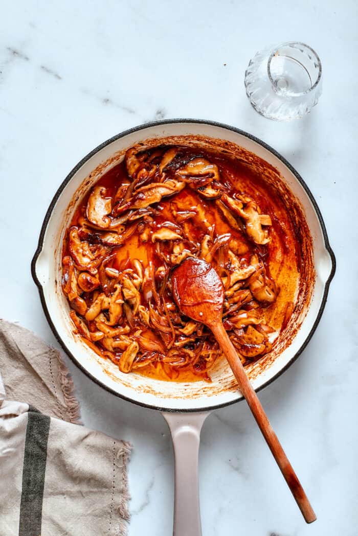 A spoon stirs the gravy in apot.