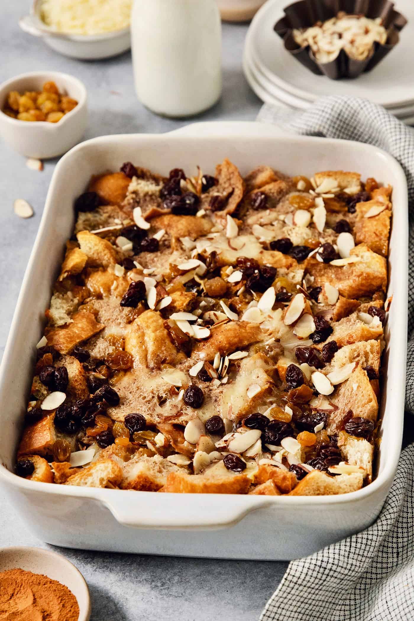 A baking dish full of capirotada topped with raisins and almonds.