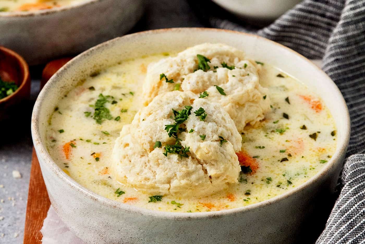 Tender biscuits atop a bowl of chicken pot pie soup.