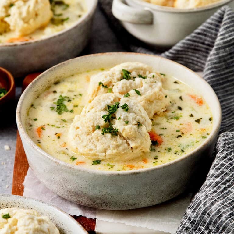 Tender biscuits atop a bowl of chicken pot pie soup.