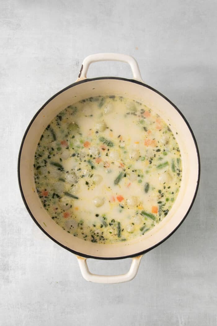 Half and half is added to the pot of soup.
