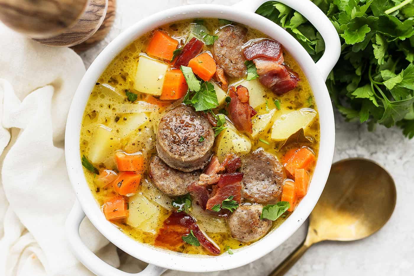 A white handled bowl with a serving of German potato soup.