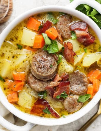 A white handled bowl with a serving of German potato soup.