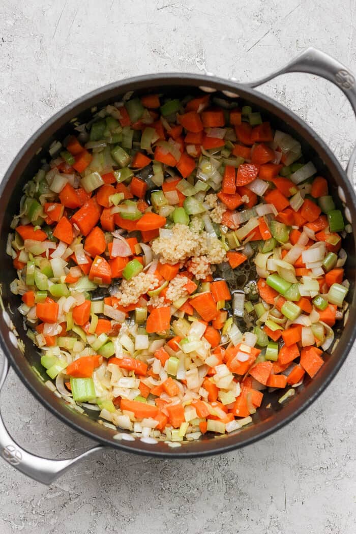 The carrots, celery, leek, onion, and garlic cook down in the cast iron pan.