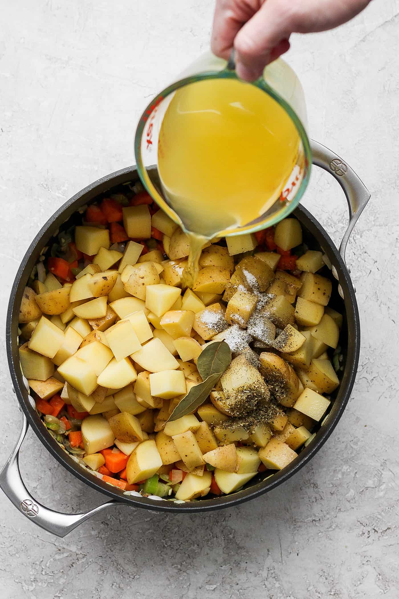This German Potato Soup recipe is packed with savory sausage, salty bacon, and plenty of vegetables plus a spoonful of half-and-half. Chicken broth is added to the vegetable medley and potatoes.