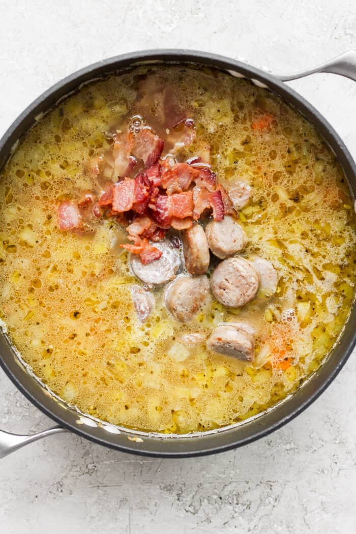 Bacon and sausage are added into the pot of German potato soup.
