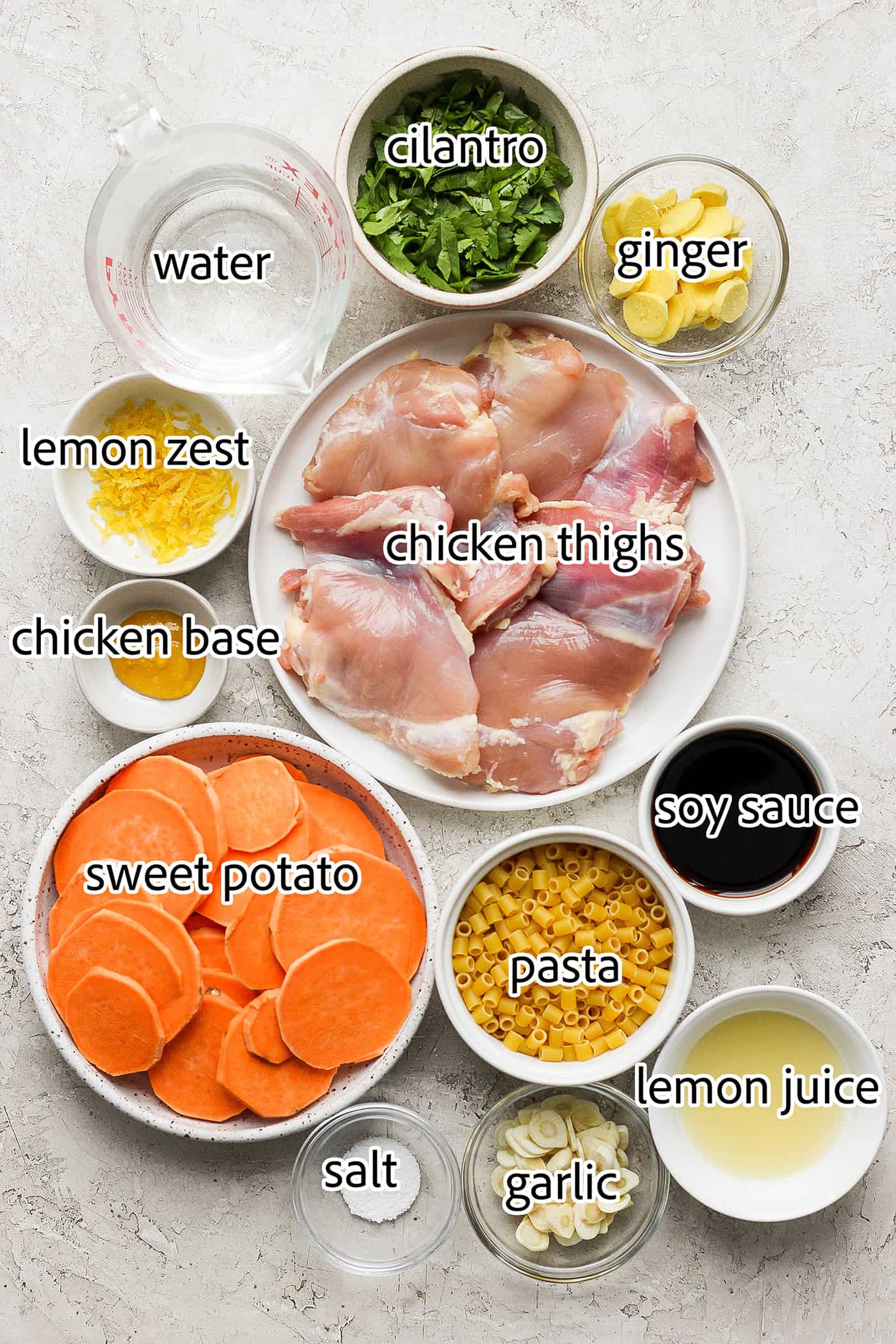 Ingredients needed to make ginger chicken soup include chicken thighs, sweet potatoes, lemon zest and juice, garlic, ginger, soy sauce, pasta, water, salt and pepper.