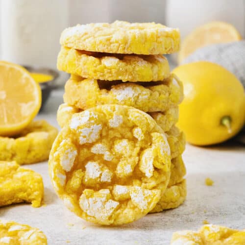 A stack of yellow lemon crinkle cookies with one turned on its side.