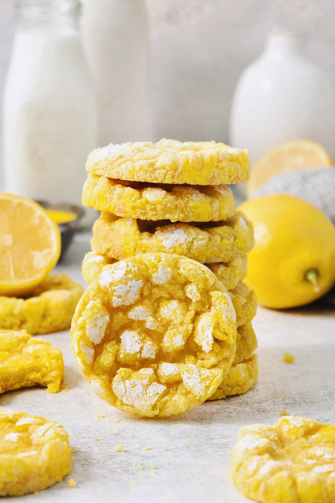 These Lemon Crinkle Cookies bake up perfectly, with a classic chewy interior and crisp exterior, and are packed with fresh lemon flavor. A stack of yellow lemon crinkle cookies with one turned on its side.
